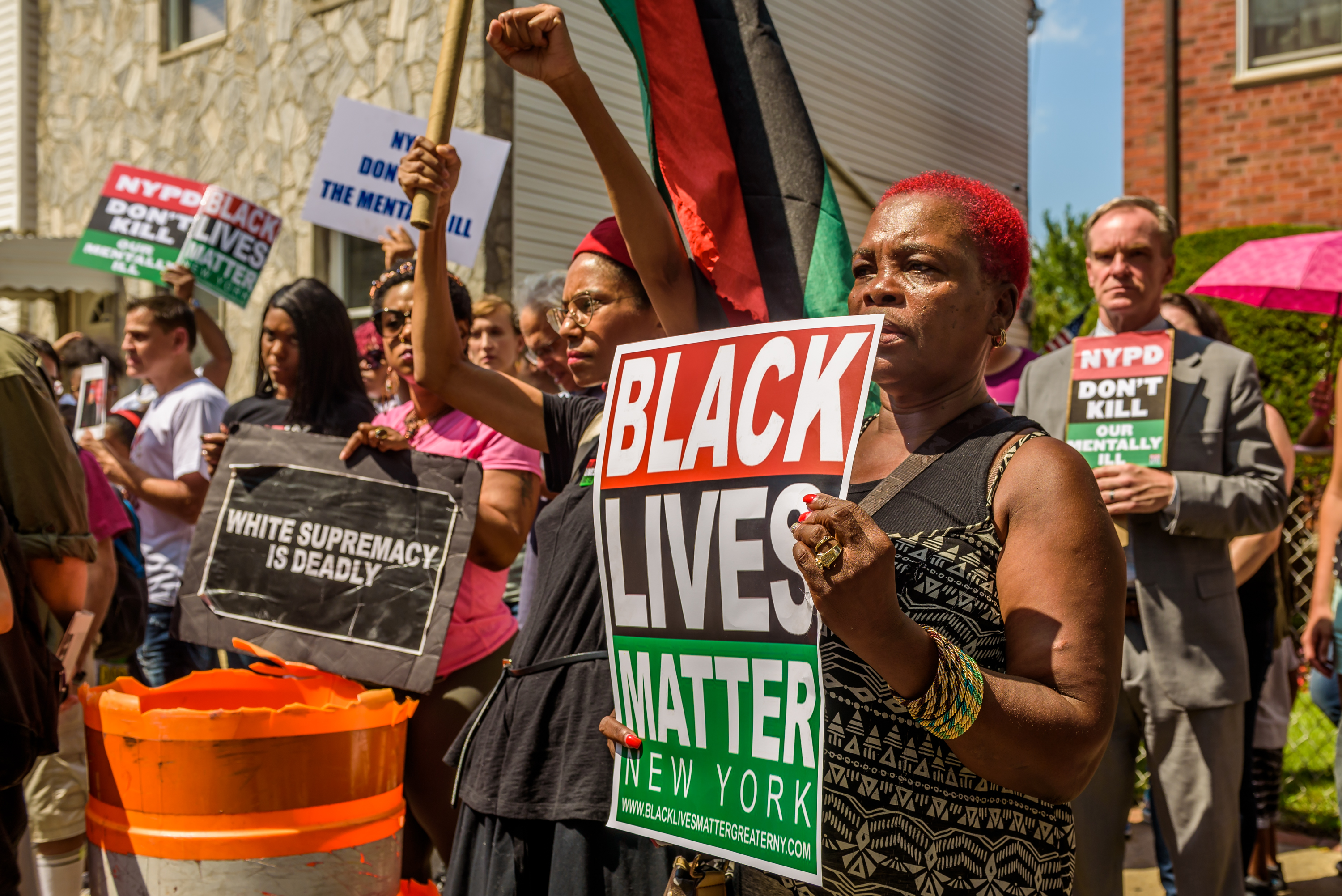 Over a hundred people gathered in front of the home of...