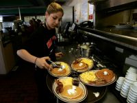 Gaby Estrella (Cq), prepares a tray of Grand Slam breakfast at Denny's Restaurant in Santa Ana on t