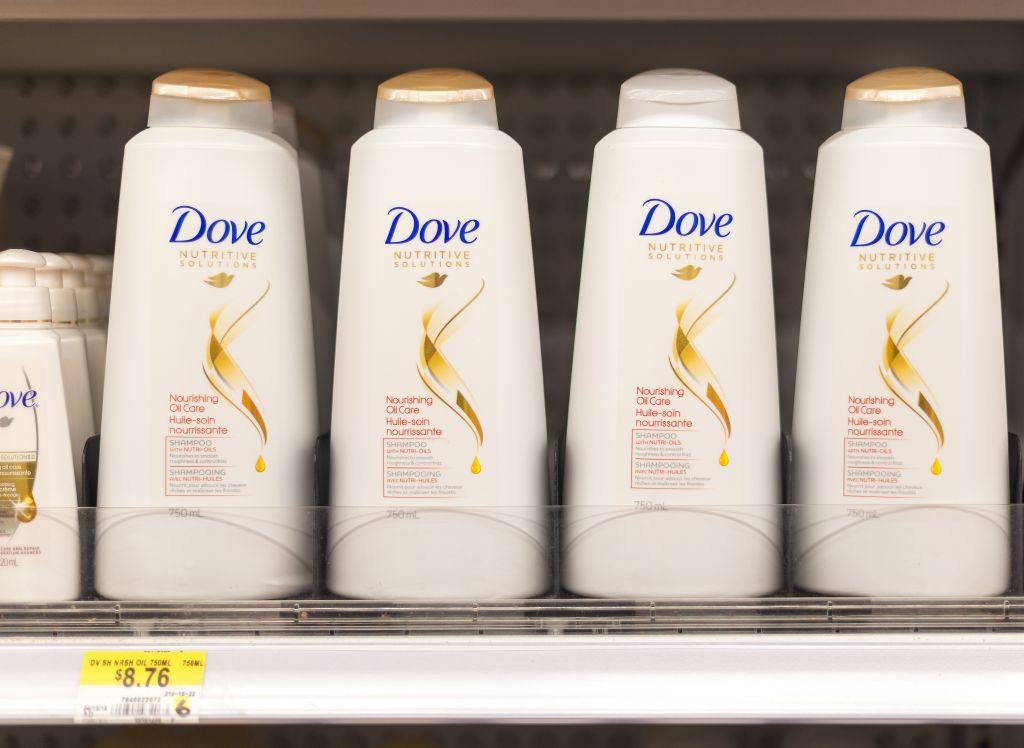 Dove shampoo and conditioner bottles in a shelf. Dove is one...