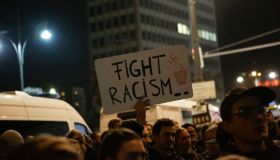 A protester holds up a sign that reads 'Fight racism'.