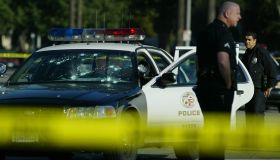 A bulletriddled LAPD patrol car sits disabled on St. Andrews Place and Venice Blvd Thursday morning