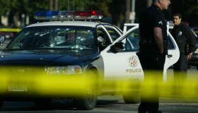 A bulletriddled LAPD patrol car sits disabled on St. Andrews Place and Venice Blvd Thursday morning