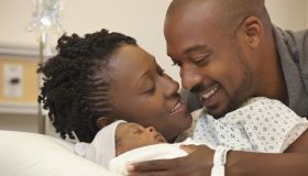 Black couple in hospital looking at newborn baby