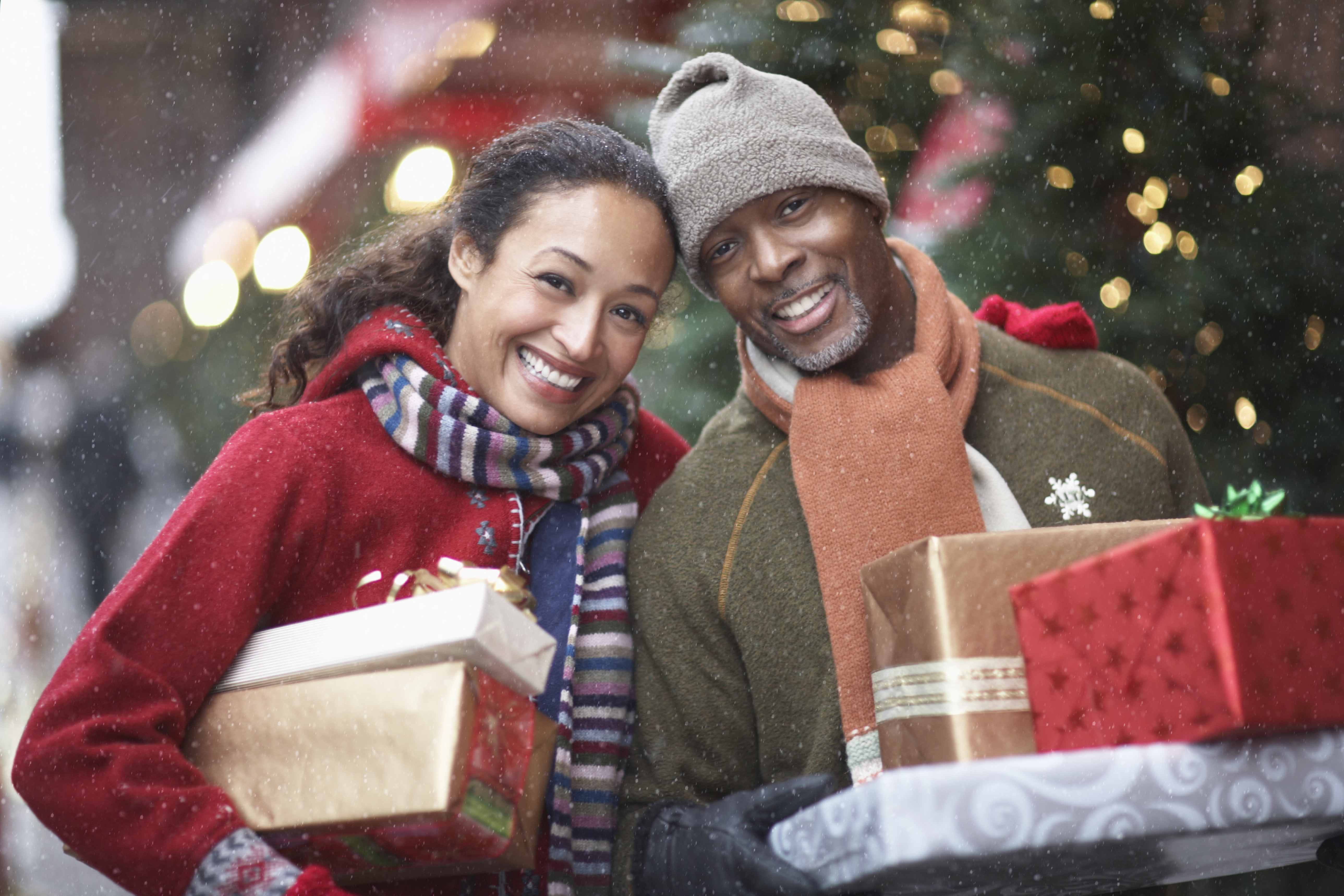 Couple with Christmas presents on street, portrait
