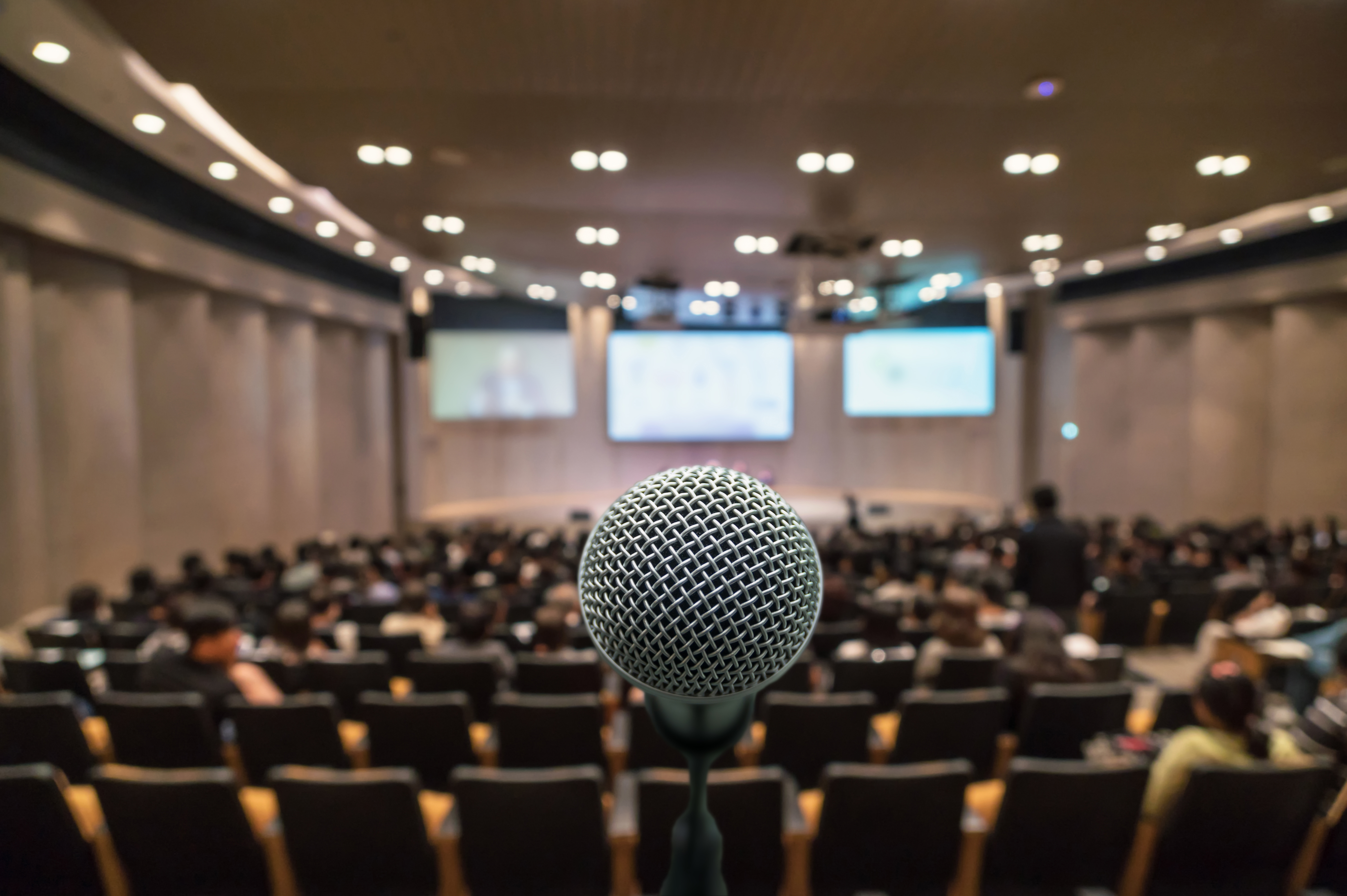 Business meeting concept, Microphone over the Abstract blurred photo of conference hall background