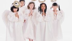Diverse group of girls wearing angel costumes praying