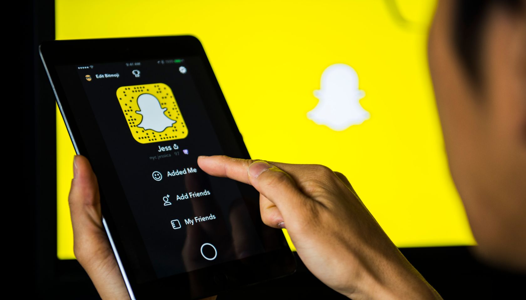 Young man holds a smart device while using SnapChat app