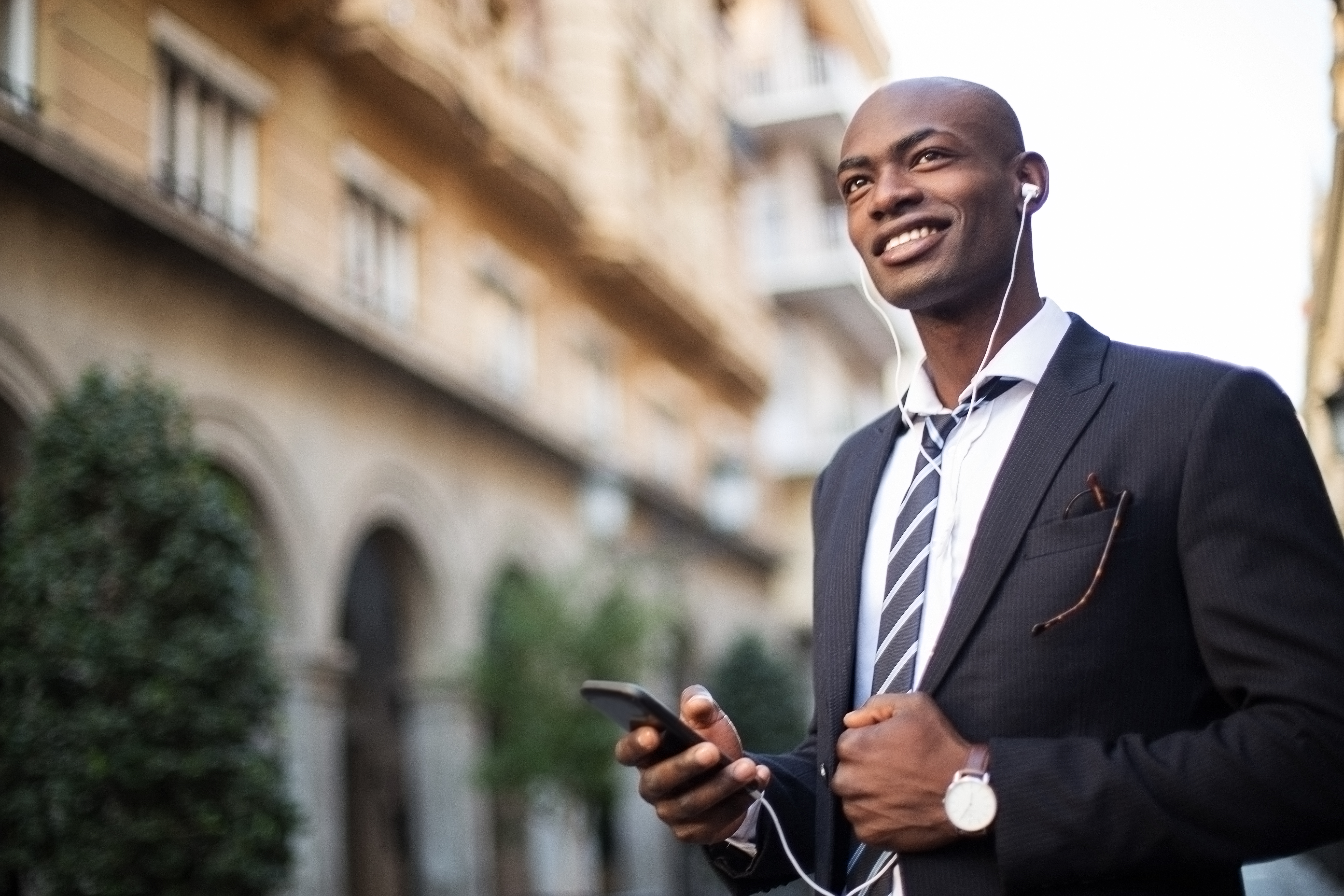 Smiling African businissman using mobile phone.
