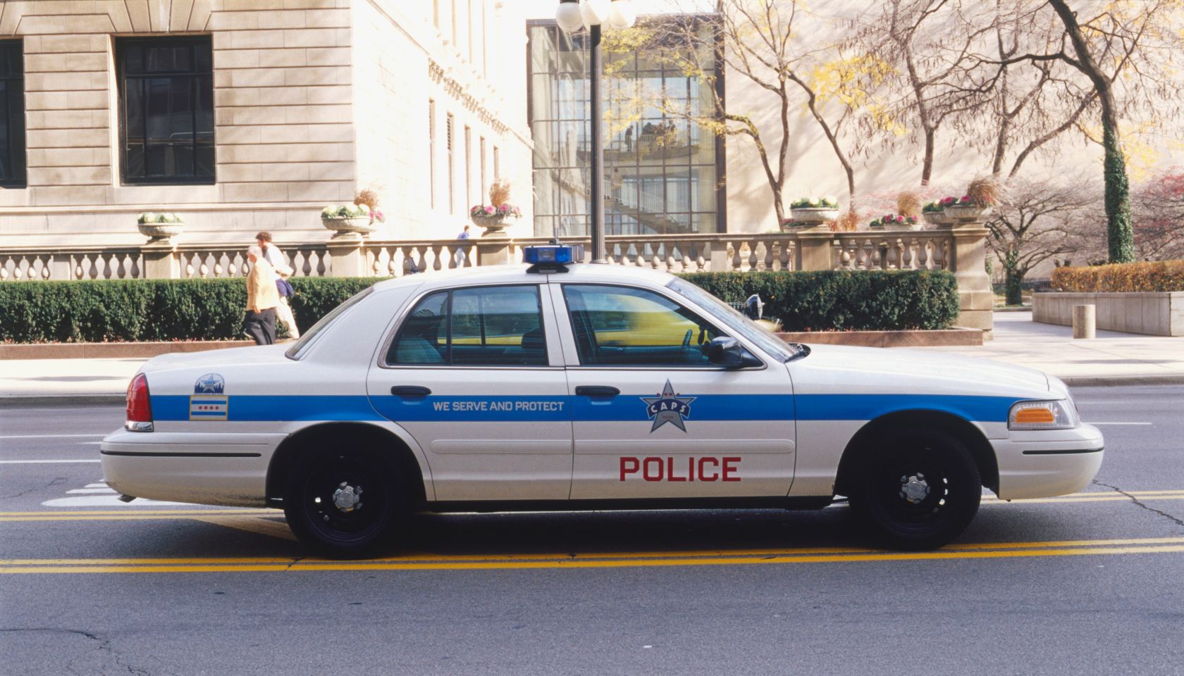 USA, Illinois, Chicago, police car driving along street, side view.