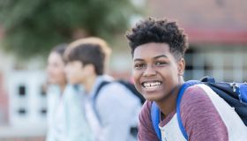 Teenage boy smiles for camera during school break