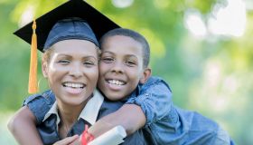 Tween son poses with mom after her college graduation ceremony