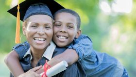 Tween son poses with mom after her college graduation ceremony