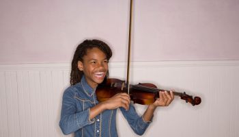 Girl (10-11) playing violin, laughing