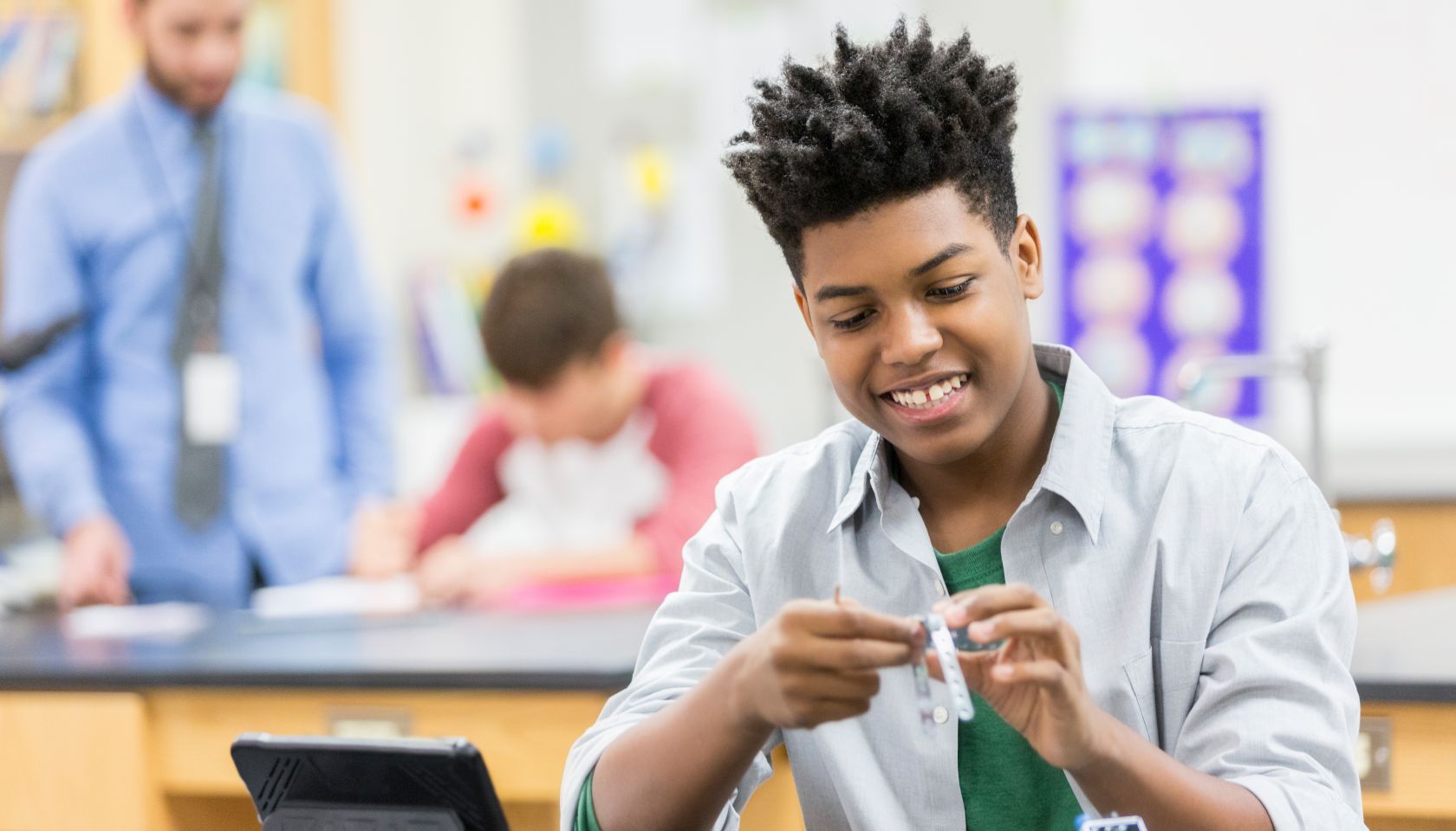 Teenage boy enjoys building a robot at school