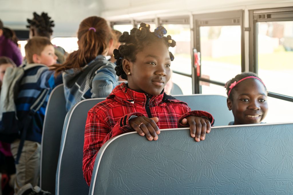 Group of multi-ethnic kids sitting on school bus.