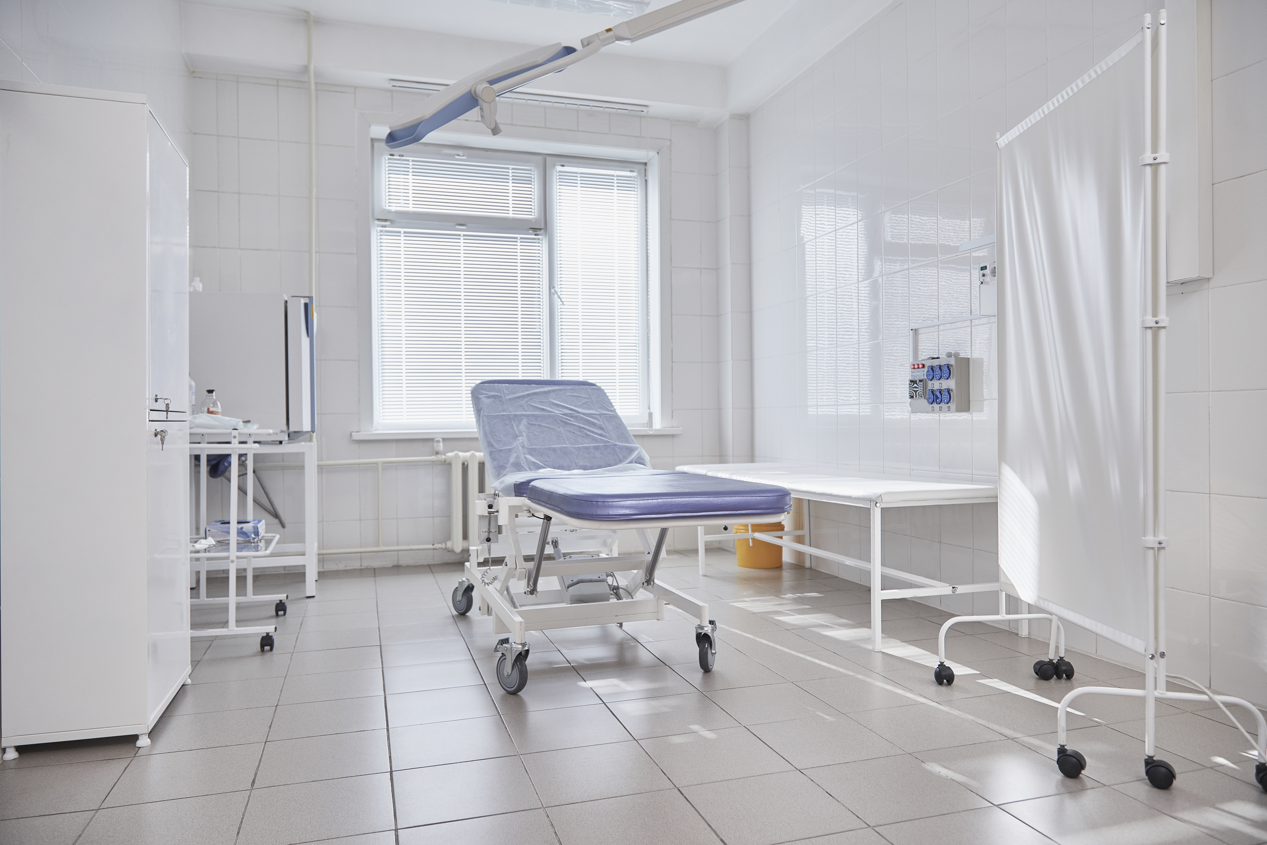 Hospital gurney by window in empty ward