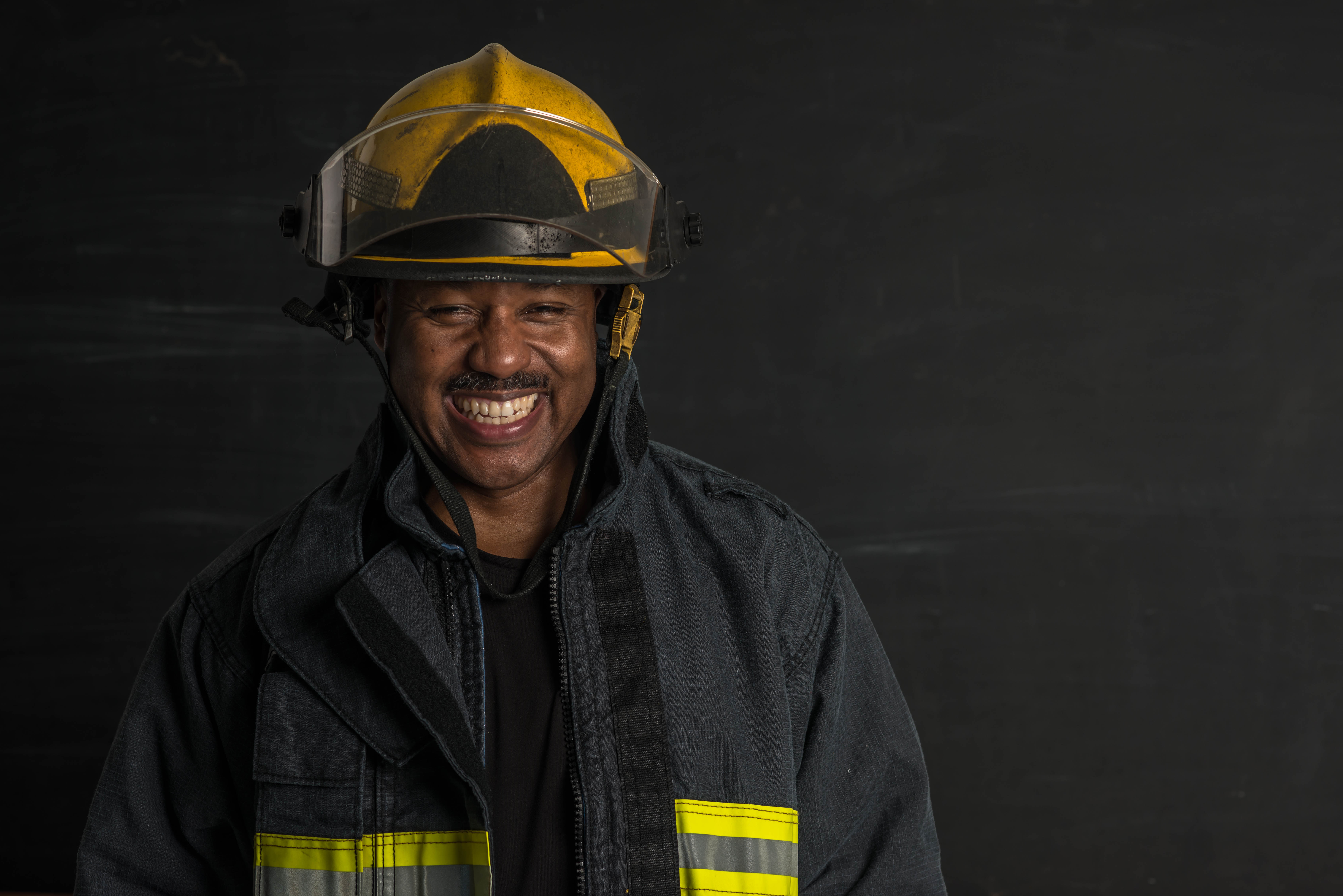Portrait of an ethnic patriotic fireman wearing gear