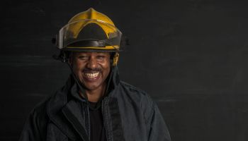 Portrait of an ethnic patriotic fireman wearing gear