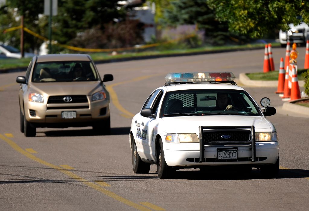 People picks up their car at the parking lot of Century Aurora 16 movie theater by the Police car escort at in Aurora, CO. Saturday, July 21, 2012. Hyoung Chang, The Denver Post