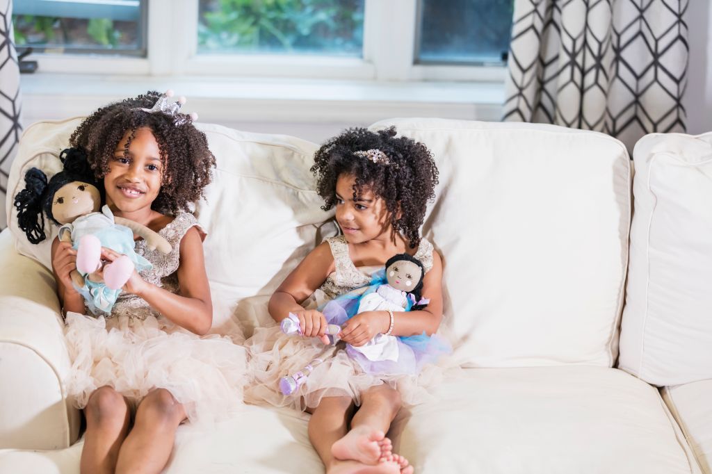 Mixed race sisters playing with dolls