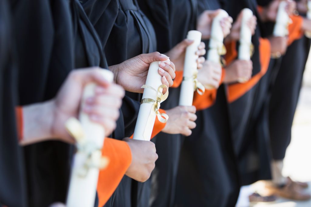 Multi-ethnic teenage graduates in cap and gown