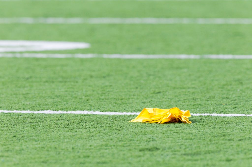 Penalty flag laying on American football field