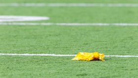 Penalty flag laying on American football field