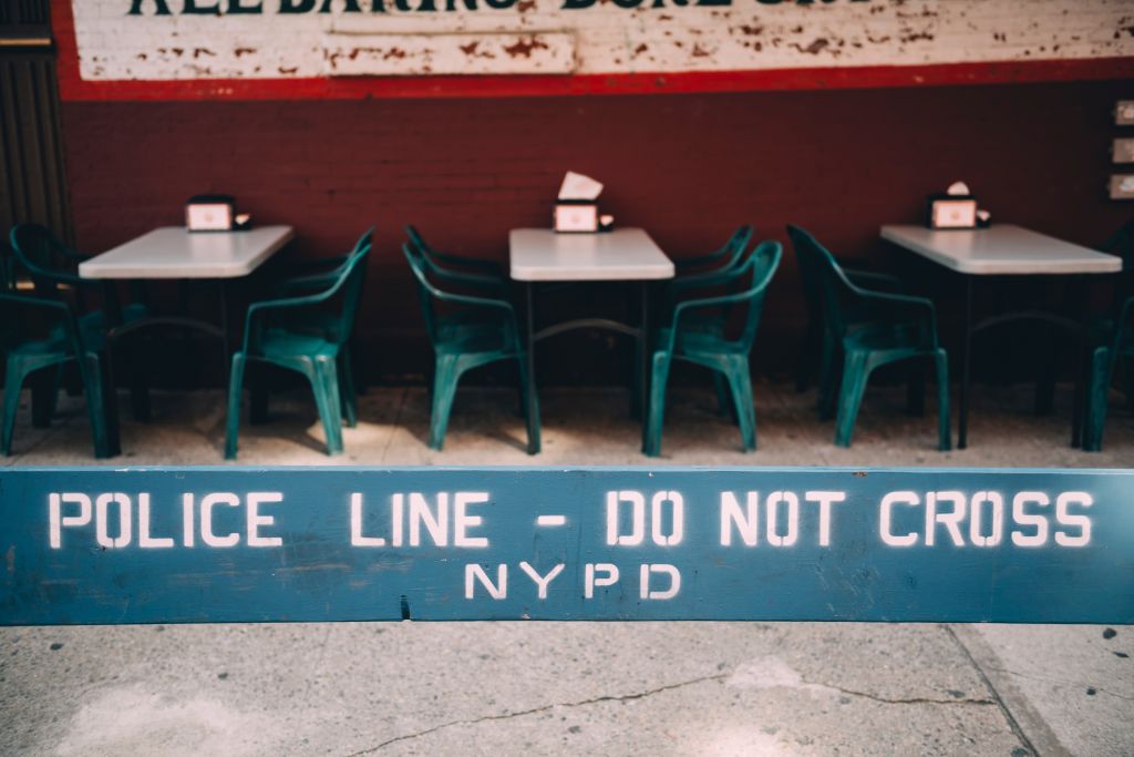USA, New York, New York City, Poline line, do not cross, empty street restaurant in the background