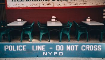 USA, New York, New York City, Poline line, do not cross, empty street restaurant in the background