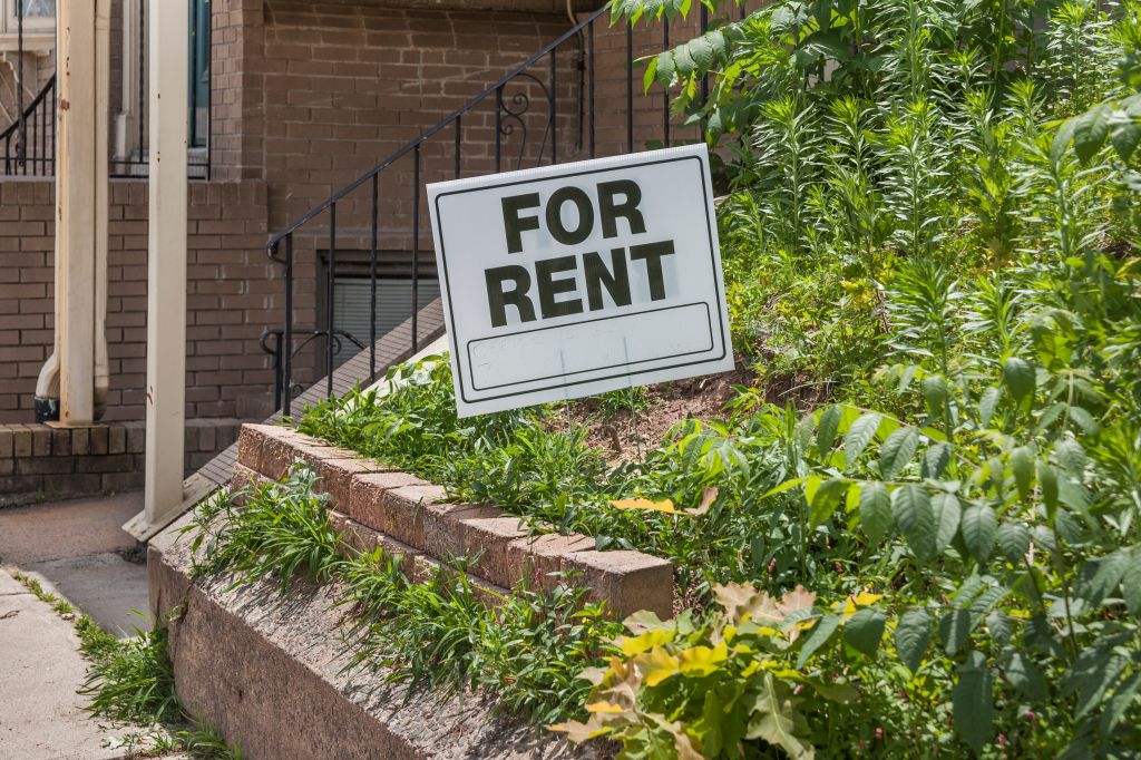 'For Rent' sign in front of a house.