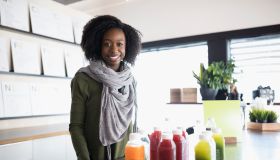 Portrait smiling young woman working at juice bar