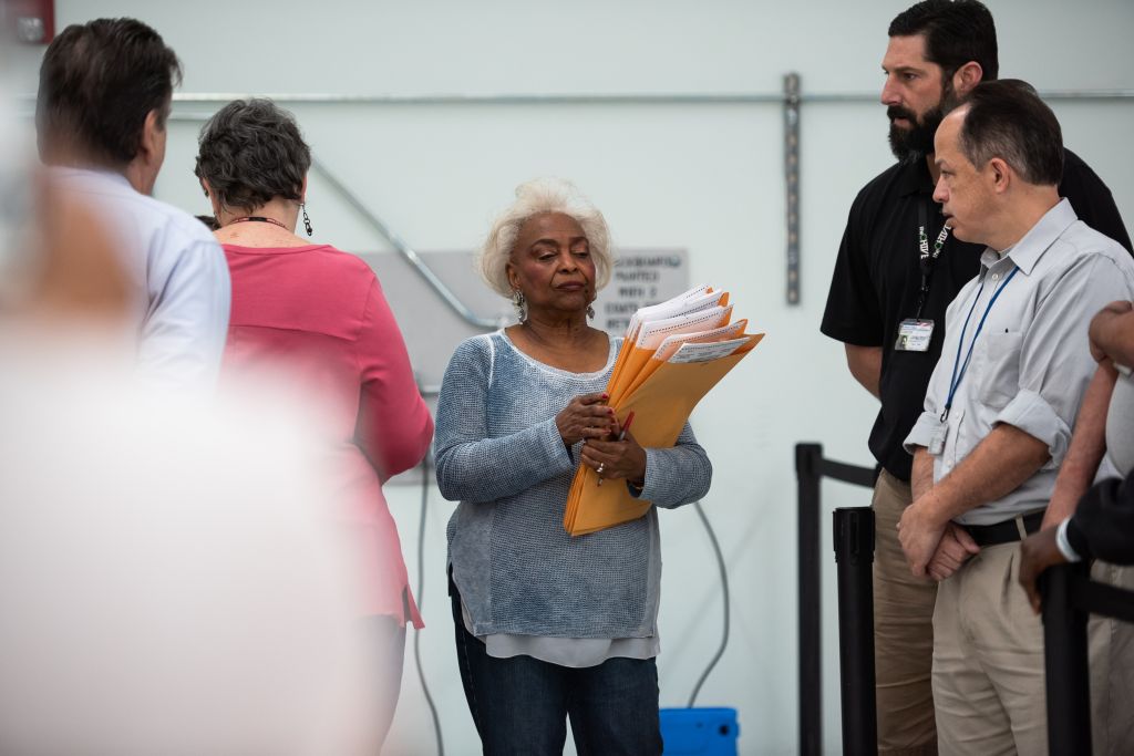 Brenda Snipes, Supervisor of Elections seen leading the hand...
