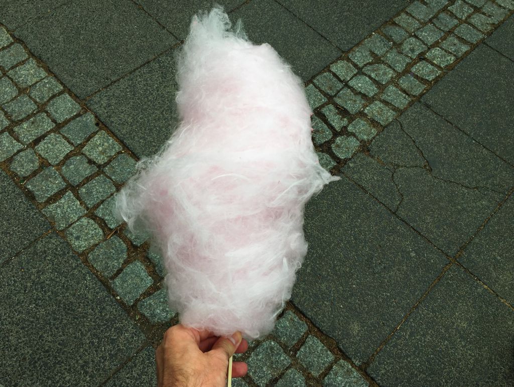 Cropped Hand Holding Cotton Candy Over Road