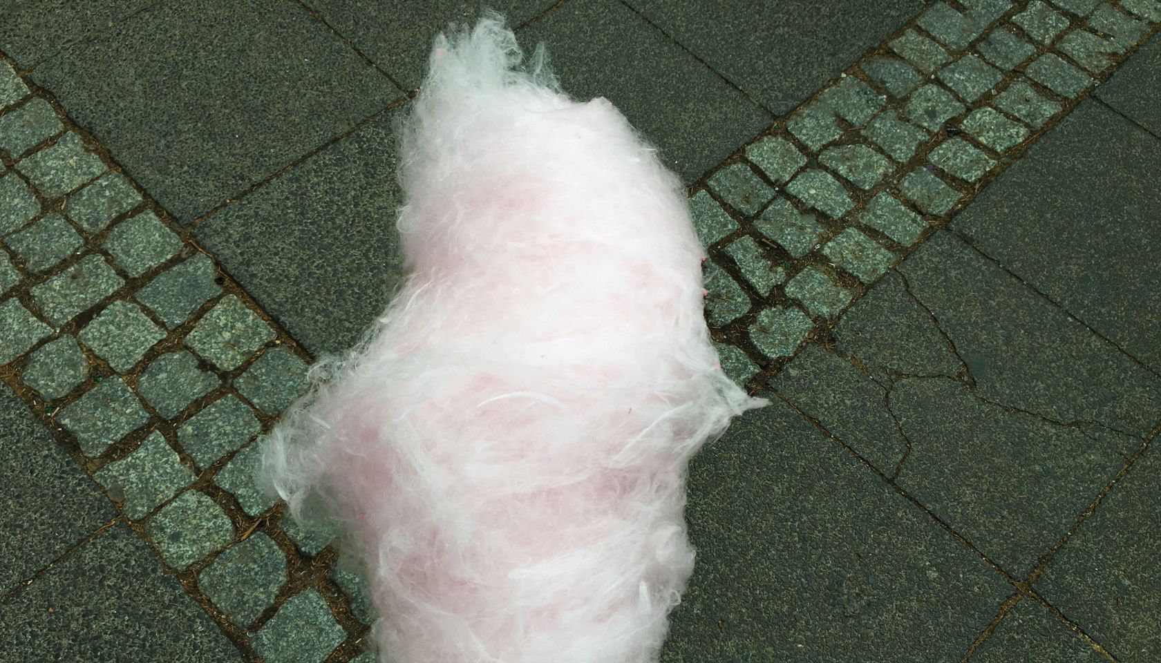 Cropped Hand Holding Cotton Candy Over Road