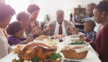 Family saying grace at holiday table