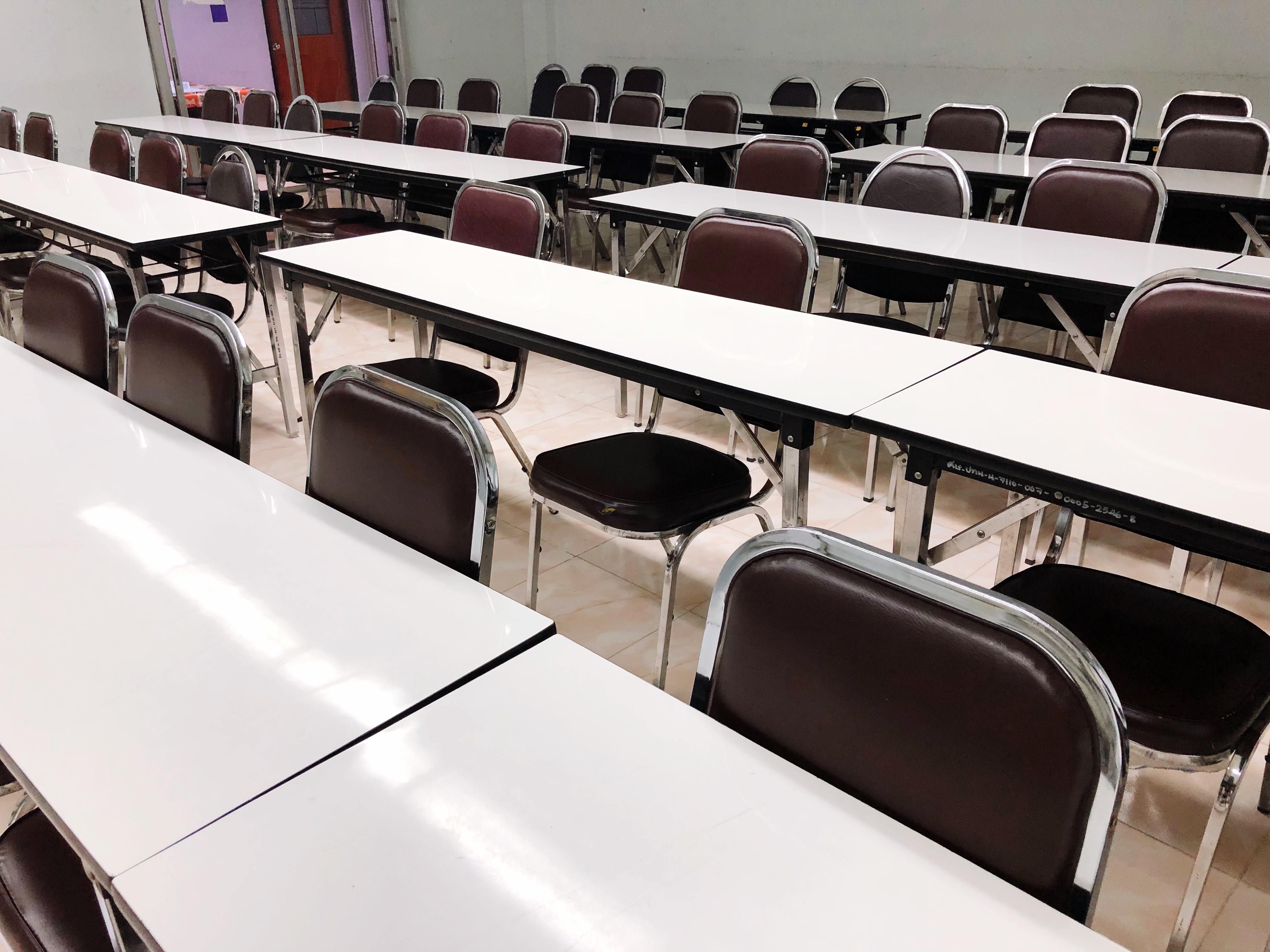 Empty Chairs Arranged At Tables In Lecture Hall