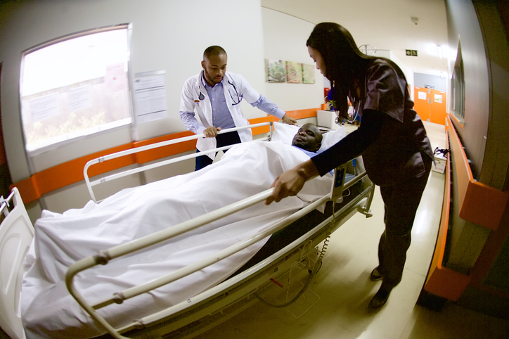 Side motion view of two doctors rushing an ill patient to Intensive Care