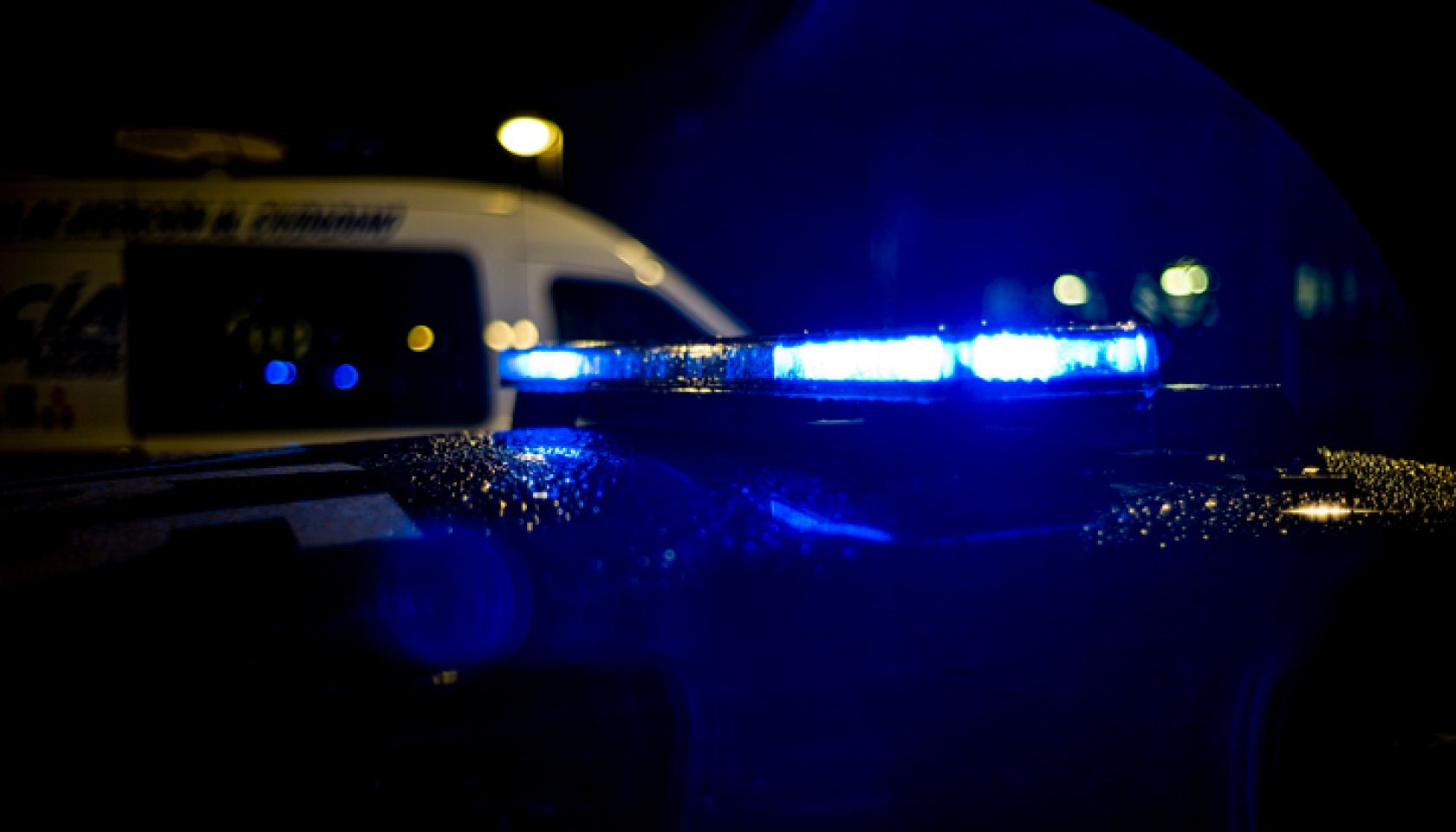 Spain, Madrid, rain falling on a police car at night