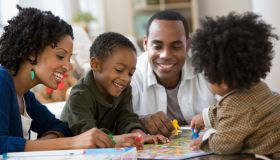 African American family playing board game together