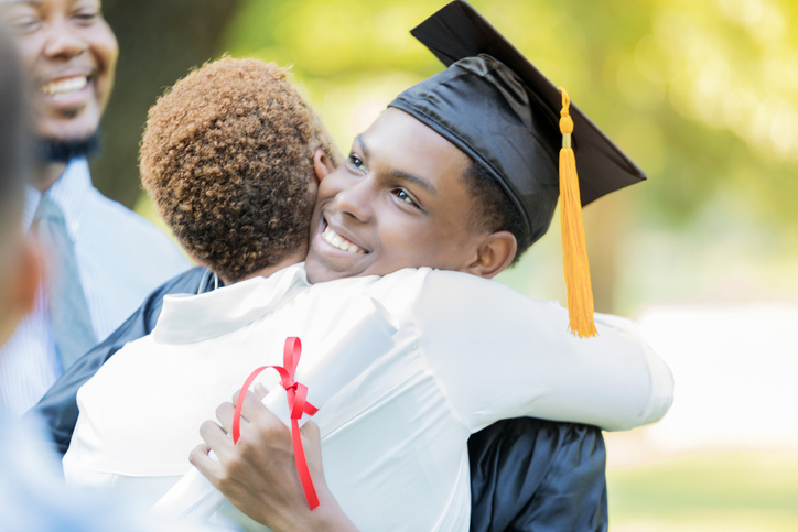 Proud mom hugs her son after graduation