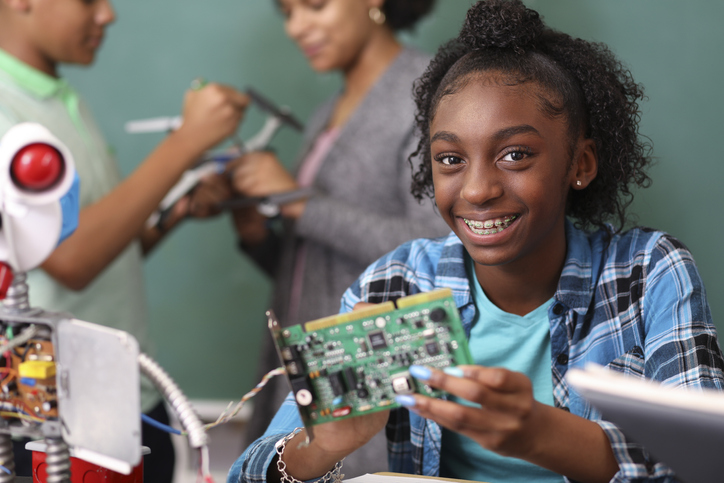 Junior high school age school students build robot in technology, engineering class.