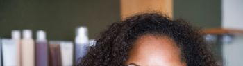 African American woman in front of hair care products