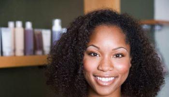 African American woman in front of hair care products