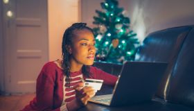 African American woman online Christmas shopping at home