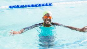 African-American girl with swimming cap, googles in pool