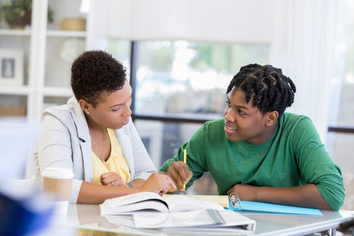 Mid adult mom helps son with homework