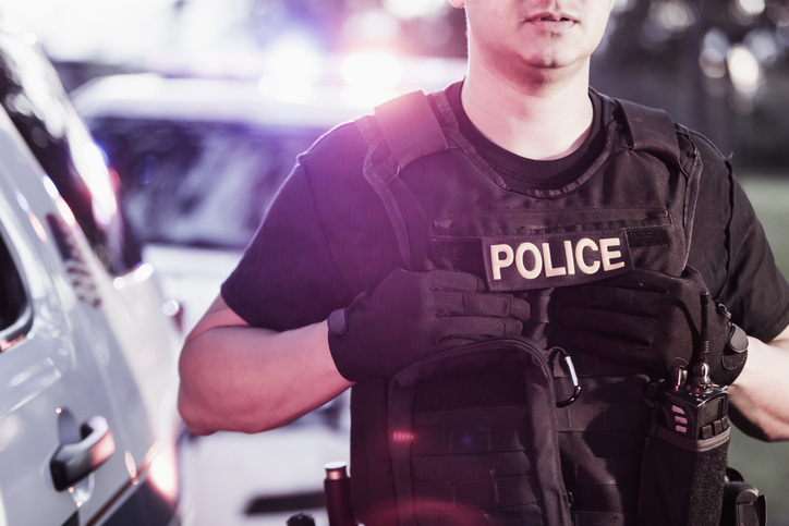 Hispanic police officer wearing bulletproof vest