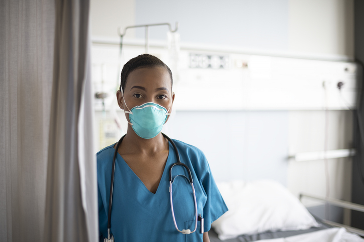 Indoor portrait of young African nurse wearing N95 face mask