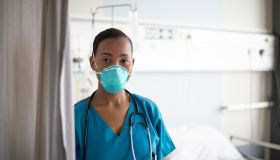 Indoor portrait of young African nurse wearing N95 face mask