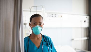Indoor portrait of young African nurse wearing N95 face mask